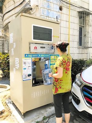 5月24日，瓊山區(qū)上丹花苑小區(qū)居民陳女士在使用共享凈水機(jī)取水。 本報記者 陳歆卓 攝